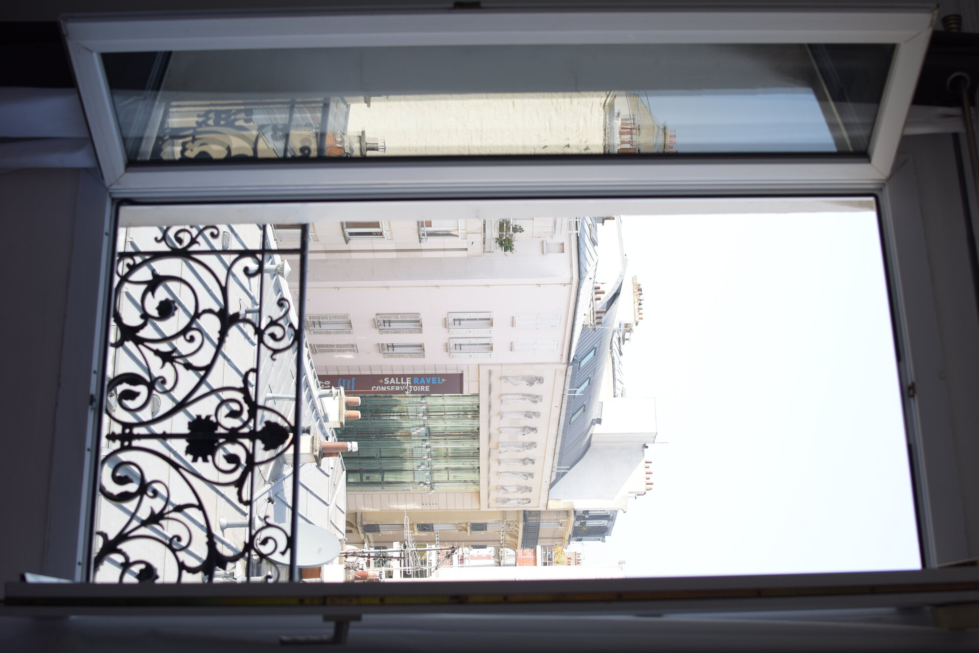 Vue sur la rue depuis la fenêtre avec balcon en fer forgé